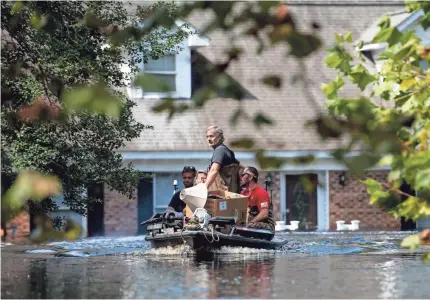  ?? GETTY IMAGES ?? People use a boat to rescue valuables from a home near the Waccamaw River on Sunday in Conway, S.C.