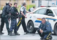  ?? CP PHOTO ?? In this file photo, police keep watch on a house as they search for a heavily armed gunman following the shooting of three Mounties in Moncton, N.B., on June 5, 2014. Arming front line officers with carbine rifles was a “high priority” for senior...
