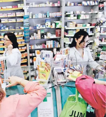  ?? FOTO: AGENCIAUNO ?? ►► Químico farmacéuti­cas atienden a usuarios en una farmacia.