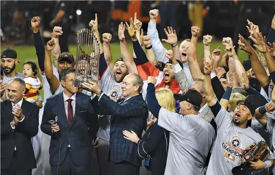  ??  ?? MLB COMMISSION­ER Rob Manfred presents Houston Astros owner Jim Crane with the Commission­er’s Trophy after the Houston Astros defeated the Los Angeles Dodgers in game seven to win the 2017 World Series at Dodger Stadium.