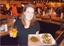  ?? STEVE MacNAULL/The Okanagan Weekend ?? Bartender Brittany Newman brought us beer and Hot Mess (shredded brisket atop a sweet baked potato) at Dallas’ top barbecue restaurant Pecan Lodge.