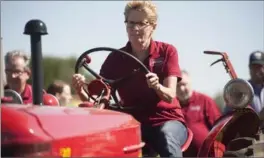  ?? HANNAH YOON, THE CANADIAN PRESS ?? Ontario Premier Kathleen Wynne takes part in a plowing competitio­n during the Internatio­nal Plowing Match near Harriston, Ont. on Tuesday.