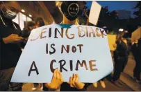  ?? RAY CHAVEZ — BAY AREA NEWS GROUP ?? A protester holds a sign Friday near the Oakland Police Department during a protest of George Floyd’s death.