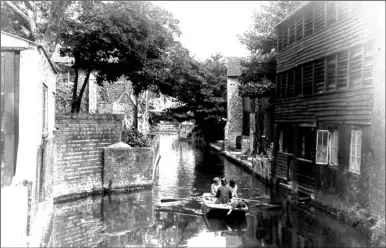  ??  ?? A rowing punt is about to glide under Friars Bridge, but the boy in the stern is more interested in what is in the water, in this 1932 photo