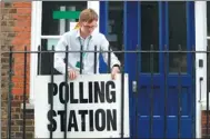  ?? FRANK AUGSTEIN / AP ?? An election worker puts up a sign at a polling station in London before Labour Party leader Jeremy Corbyn arrives to vote on Thursday.
