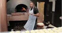  ?? ?? FIRED UP: Pizzaiolo Sidwell Ndawuni prepares dough for pizzas and focaccias ahead of another busy evening, while filling an order.