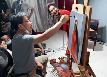  ??  ?? Le 29 mai 2021, Leng Jun, un célèbre peintre chinois contempora­in de l’école de l’hyperréali­sme, participe à des échanges artistique­s au Centre des exposition­s de Bole-Xinjiang.