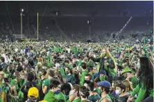  ?? Matt Cashore / Associated Press ?? Fans storm the field after Notre Dame defeated Clemson 4740 in two overtimes in South Bend, Ind., on Nov. 7.