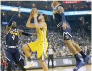  ??  ?? ANDA CHU/BAY AREA NEWS GROUP Golden State Warriors' Klay Thompson (C) drives to the hoop against Denver Nuggets' Paul Millsap (L) and Gary Harris in an NBA game at Oracle Arena in Oakland, CA, the US, on March 8, 2019.