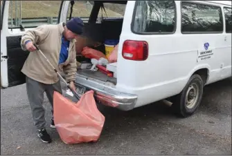  ?? The Sentinel-Record/Richard Rasmussen ?? LITTER ABATEMENT: Hope Works Director David Cook looks through some trash on Malvern Avenue Tuesday.