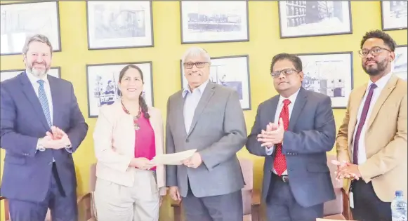  ?? ?? Executive Chairman of DDL, Komal Samaroo (centre) and IDB Resident Representa­tive Lorena Solorzano-Salazar holding the loan document. Minister of Finance Ashni Singh is second from right. (Ministry of Finance photo)