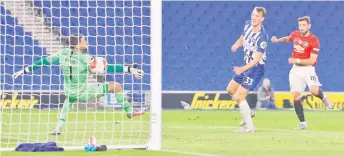  ?? — AFP photo ?? Manchester United’s midfielder Bruno Fernandes (right) scores their third goal during the English Premier League match against Brighton and Hove Albion at the American Express Community Stadium in Brighton, southern England.