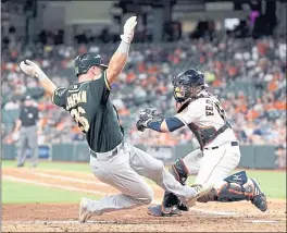  ?? DAVID J. PHILLIP — ASSOCIATED PRESS ?? The A’s Matt Chapman eludes the tag of Astros catcher Tim Federowicz to score an insurance run in the ninth inning of Wednesday night’s 8-3 victory.