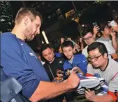  ?? PROVIDED TO CHINA DAILY ?? NBA All-Star Dirk Nowitzki (left) of the Dallas Mavericks signs autographs after arriving in Shanghai on Tuesday night, while Philadelph­ia 76ers center Joel Embiid also receives a warm welcome in the same city on Wednesday morning.