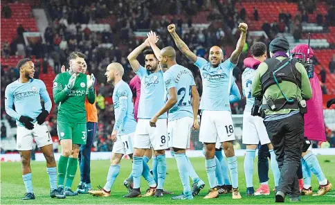  ?? — AFP photo ?? Manchester City’s English midfielder Fabian Delph (2R) celebrates with teammates at the end of the English Premier League football match between Manchester United and Manchester City at Old Trafford in Manchester, north west England, on December 10,...