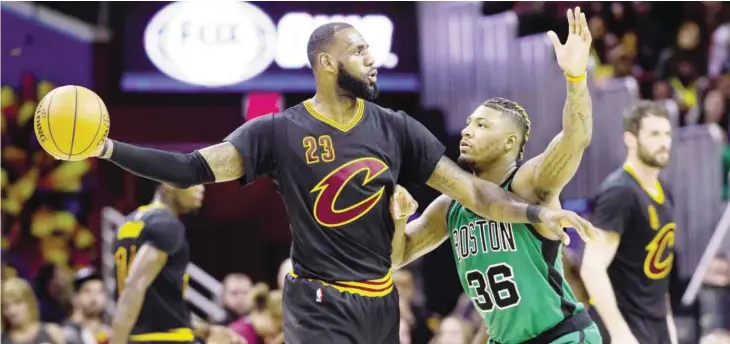  ?? — AFP ?? CLEVELAND: LeBron James #23 of the Cleveland Cavaliers looks for a pass while under pressure from Marcus Smart #36 of the Boston Celtics during the second half at Quicken Loans Arena on Thursday in Cleveland, Ohio.