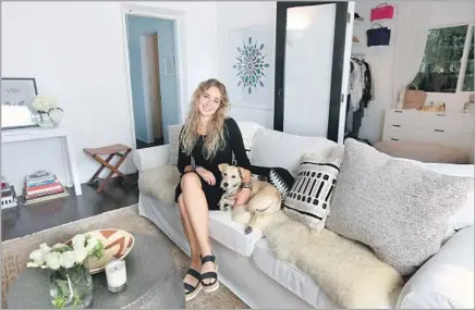  ?? Photograph­s by Glenn Koenig Los Angeles Times ?? BEATRICE FISCHEL-BOCK in her living room with her dog Ellie. She used her company’s digital design app to upgrade the room.