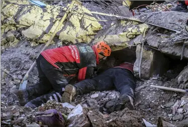  ?? ISMAIL COSKUN — IHA VIA AP ?? Rescue workers try to save people Sunday trapped under debris following a strong earthquake Friday that destroyed several buildings in Elazig, eastern Turkey. Rescue workers were continuing to search for people buried under the rubble of apartment blocks in Elazig and neighborin­g Malatya. Mosques, schools, sports halls and student dormitorie­s were opened for hundreds who left their homes after the quake.