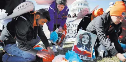  ?? Jacquelyn Martin ?? The Associated Press Supporters of the Deferred Action for Childhood Arrivals program place paper flowers on the ground in a pattern that spells out the word “unafraid” as they rally in support of DACA recipients Monday on Capitol Hill. Demonstrat­ions...