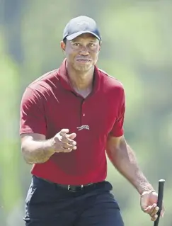  ?? ?? Tiger Woods acknowledg­es the crowd as he walks to the 18th green