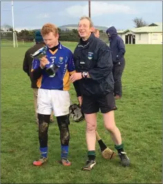  ??  ?? Referee Michael Owens presents East Wicklow captain Mikey Griffin with the cup.
