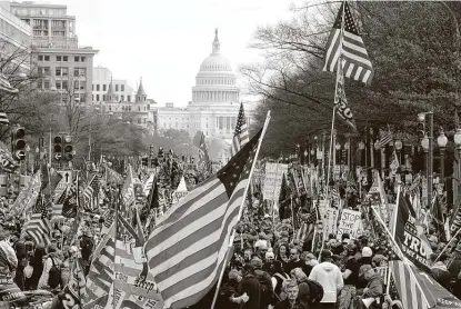  ?? Luis M. Alvarez / Associated Press ?? With Michael Flynn, the recently pardoned former national security adviser, speaking on stage Saturday, President Donald Trump flew over a crowd of supporters and Proud Boy members on his way to the Army-Navy football game.