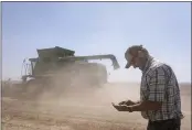  ?? NATHAN HOWARD — THE ASSOCIATED PRESS ?? Phil Fine checks for carrot seeds in the soil left behind by a combine while harvesting a field in the North Unit Irrigation District near Madras, Ore., on Tuesday.