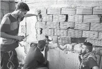  ??  ?? ABOVE: Militia fighters look for enemy forces from a position in Suani. BELOW: A notebook with Russian writing found on the front line by a militiaman aligned with Libya’s government.