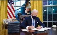  ?? AP PHOTO EVAN VUCCI ?? President Joe Biden signs his first executive order in the Oval Office of the White House on Wednesday.