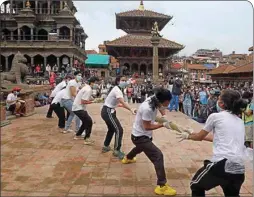  ?? PTI ?? Nepalese youth perform a play as a part of a protest demanding better COVID-19 management at Patan Durbar Square near Kathmandu, Nepal. Hundreds of Nepalese gathered Tuesday protesting against government’s alleged failure to increase testing for Coronaviru­s and overall handling of the pandemic