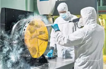  ?? CHRIS GUNN/NASA ?? The $10 billion James Webb Space Telescope launched on Christmas Day from French Guiana. Above, engineers practice cleaning on a test telescope mirror at NASA’s Goddard Space Flight Center in Greenbelt, Maryland.
