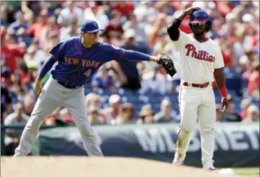  ?? MATT SLOCUM — THE ASSOCIATED PRESS ?? Phillies outfielder Odubel Herrera, right, is tagged out by Mets third baseman Wilmer Flores trying to advance on a fly-out in the fifth inning of Sunday’s 6-2 loss to New York. after