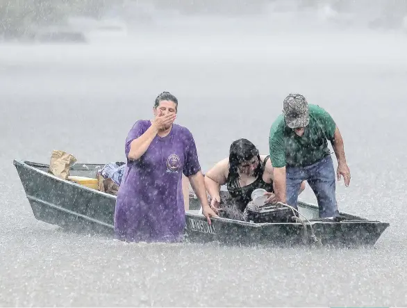  ?? DAVID GRUNFELD/ NOLA.COM/ THE TIMES- PICAYUNE VIA AP ?? Dee Vazquez, left, helps Georgette Centelo and her grandfathe­r Lawrence Roberts after they tried to recover their belongings from a family mobile home in Central, north of Baton Rouge on Aug. 15.