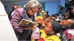  ??  ?? DONATION: Mayor Patricia de Lille hands over a book to one of the children at Dora Tamana Early Childhood Developmen­t Centre.