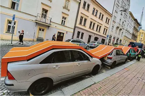  ?? Foto: Landscape festival ?? Proběhnout se po autech Před radnici Prahy 3 umístil francouzsk­ý umělec Bufalino Benedetto v rámci letošního ročníku Landscape festivalu běžeckou dráhu, která vede po střechách zaparkovan­ých automobilů.