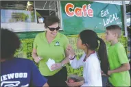  ??  ?? Director of nutrition services Nancy Rostomily assists students as Lodi Unified School District debuts its new food truck at Elkhorn Elementary in Stockton on Wednesday.