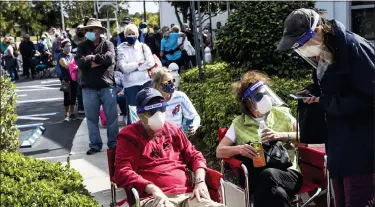  ?? ANDREW WEST — VIA THE ASSOCIATED PRESS ?? Joel and Susan Pittelman, from Naples, Fla., wait in line to receive COVID-19 vaccines on Tuesday in Lehigh Acres, Fla. There have been bumps in the road in getting coronaviru­s-fighting shots into people’s arms.