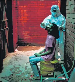  ?? REUTERS ?? A health worker in Delhi collects a swab sample from a person for a Covid-19 test.