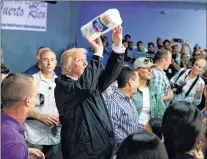  ?? AP PHOTO ?? U.S. President Donald Trump tosses paper towels into a crowd as he hands out supplies at Calvary Chapel, Tuesday, in Guaynabo, Puerto Rico.