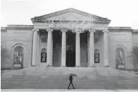  ?? JULIO CORTEZ/AP ?? A man covers himself from rain with an umbrella as he walks in front of the Baltimore Museum of Art in April.