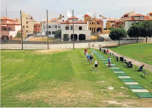  ??  ?? Varios golfistas practican sobre el green en Costa Esuri.