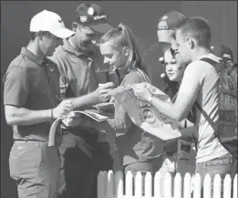  ?? DAVE THOMPSON, THE ASSOCIATED PRESS ?? Ireland’s Rory McIlroy, left, and Padraig Harrington sign autographs for fans Monday at the second practice day for the British Open Golf Championsh­ip at Royal Birkdale.