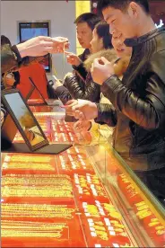  ?? LIU JUNFENG / FOR CHINA DAILY ?? Shoppers look at gold accessorie­s in a jewelry shop in Yichang, Central China’s Hubei province.