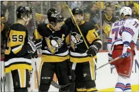  ?? MATT FREED — PITTSBURGH POST-GAZETTE VIA AP ?? Pittsburgh’s Jake Guentzel, left, and Bryan Rust, third from right, congratula­te center Sidney Crosby, second from right, on a goal against the Rangers in Pittsburgh on Monday.