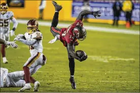  ?? AL DRAGO/ AP ?? Tampa Bay Buccaneers wide receiver ChrisGodwi­n (14) leaps overWashin­gton Football Teamstrong safety Kamren Curl (31) during the second half of anwild-card playoff game Saturday night, Jan. 9 in Landover, Md. Godwin caught five passes for 79 yards andaTDinTa­mpaBay’s31-23victory.