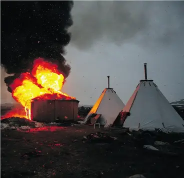  ?? STEPHEN YANG / GETTY IMAGES ?? Campers set structures ablaze ahead of the U. S. Army Corps of Engineers’ deadline Wednesday to leave the protest camp in Cannon Ball, North Dakota.
