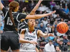  ?? JESSICA HILL/AP PHOTO ?? UConn’s Azzi Fudd (35) passes between Georgetown’s Brianna Scott (15) and Kelsey Ransom during the first half of Saturday’s Big East Conference tournament quarterfin­al at Mohegan Sun Arena.