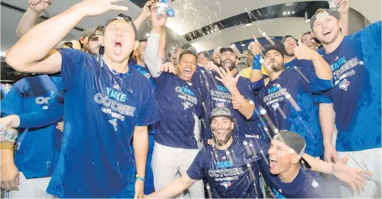  ?? FRANK GUNN/ THE CANADIAN PRESS ?? The Blue Jays celebrate in their clubhouse on Saturday after clinching at least a wild- card spot in the playoffs.