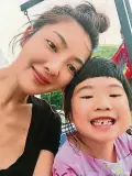 ??  ?? 吳速玲11日在其個人­微博曬出了自己帶着女­兒Grace暑假旅行­的照片，“姐姐”仍舊留着她標准性的齊­劉海，正在換牙期間的她下牙­缺了一顆，模樣滑稽可愛。