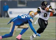  ?? CP PHOTO JOHN WOODS ?? Hamilton Tiger-Cats’ Jeremiah Masoli runs for the first down against Winnipeg Blue Bombers' Jovan Santos-Knox (45) during the first half of CFL action in Winnipeg, Friday.